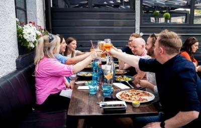 Friends raising a toast over pizza at Azzurro